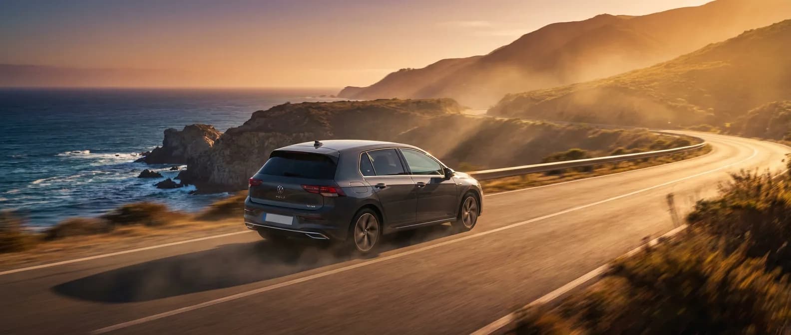 Voiture Volkswagen Golf 8 1.5 TSI 150 cv en mouvement sur une route côtière pittoresque au coucher du soleil.