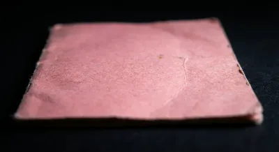 Gros plan iconique d'un ancien permis de conduire rose cartonné, soulignant sa texture et son usure.