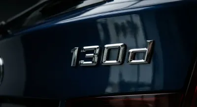 Détail emblématique du badge '130d' BMW, gros plan haute définition.