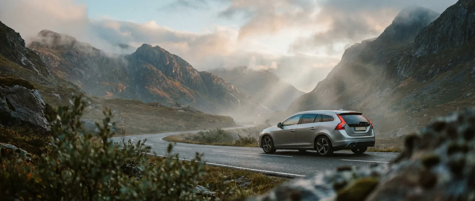 Voiture compacte sur une route de montagne à l'aube, illustrant la longévité et la route du moteur 1.5 dCi 85.