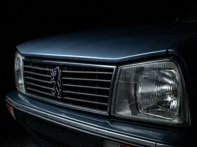 Détail emblématique de la calandre et des phares avant de la Peugeot 505 V6, fort contraste.
