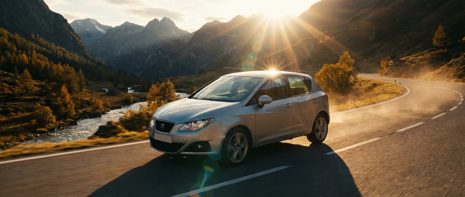 La SEAT Ibiza 6J en action dans un décor épique Vue cinématographique d'une SEAT Ibiza 6J grise sur une route de montagne au soleil couchant