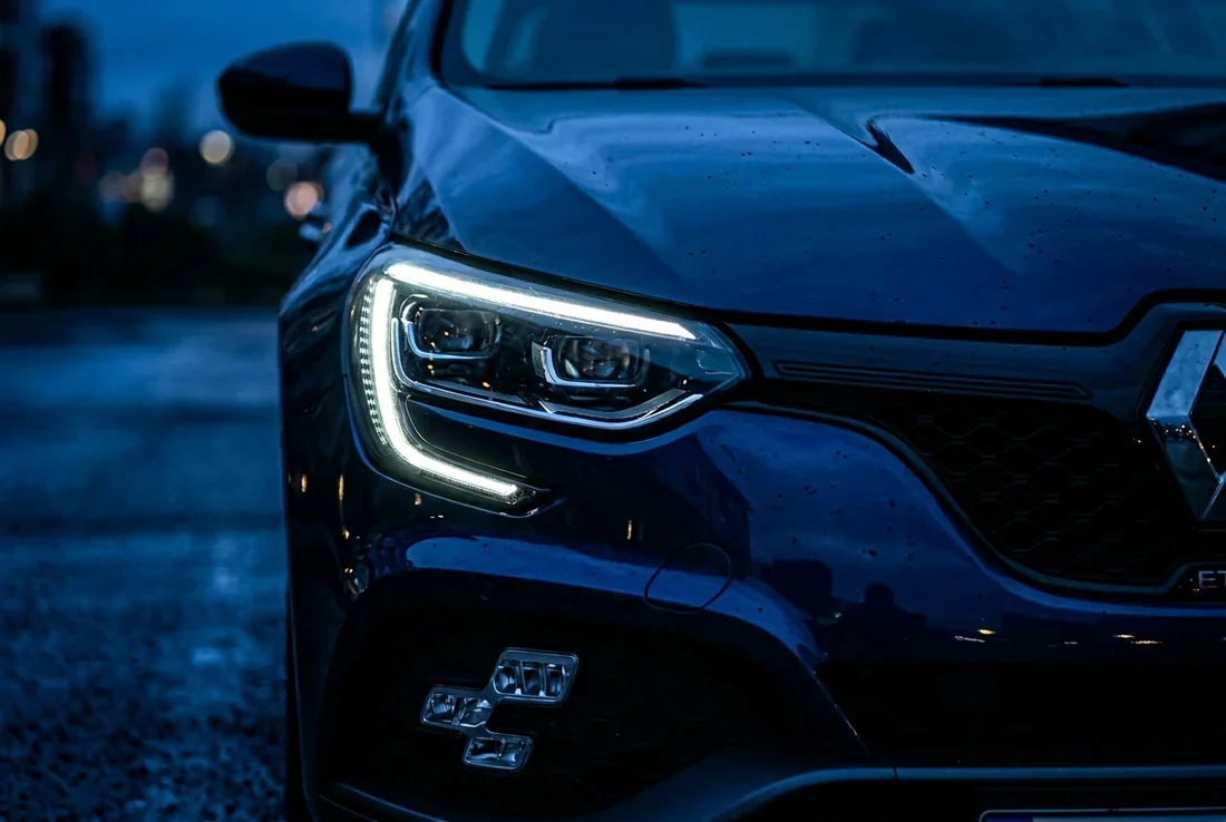 La Renault Megane E-Tech en voyage La Renault Megane E-Tech roulant sur une route côtière au coucher du soleil