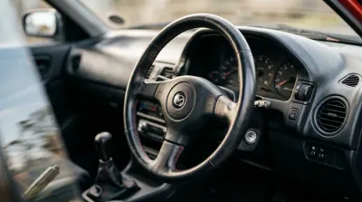 Gros plan minimaliste sur la calandre et l'optique d'une Mazda 323 Sport