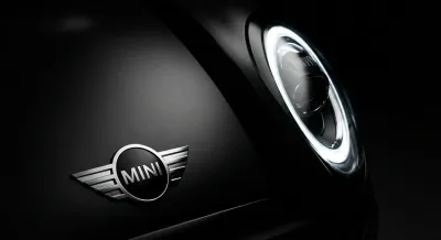 Gros plan emblématique du logo et du phare d'une Mini Cooper.