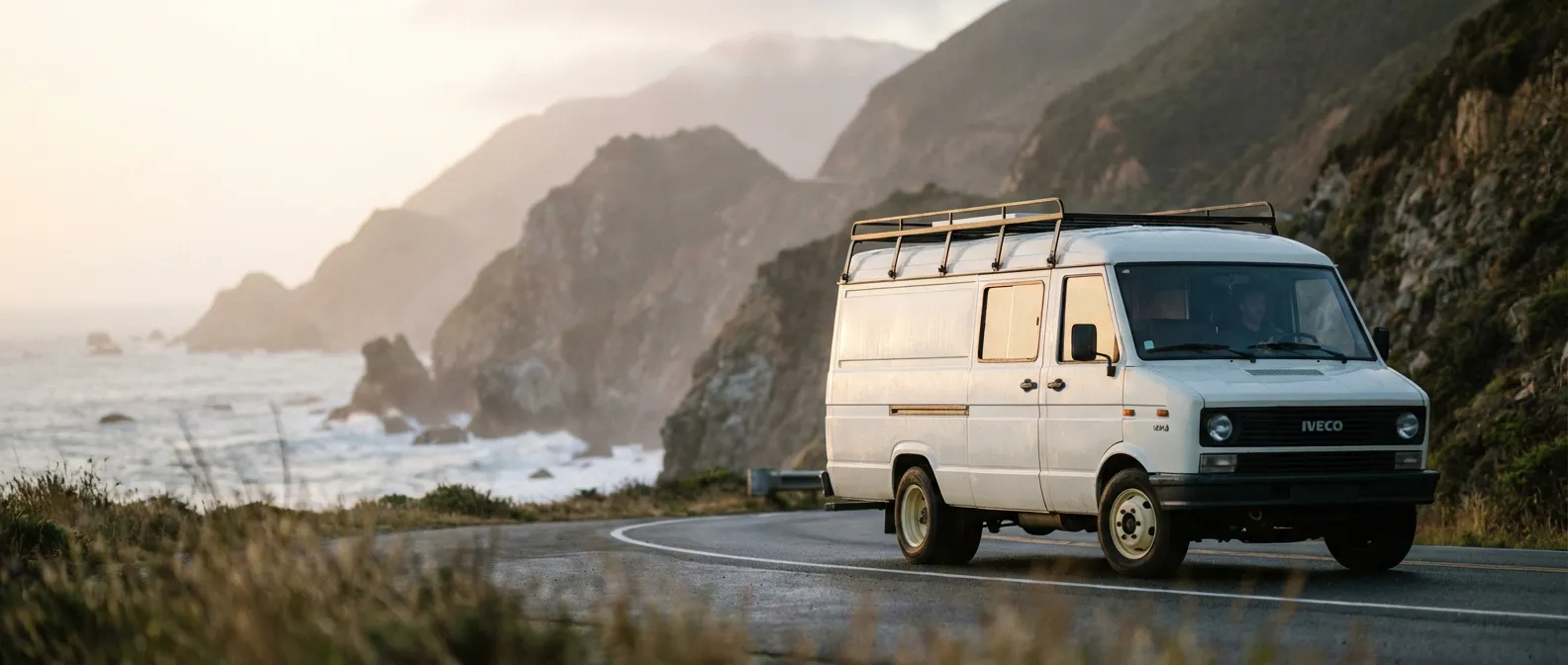Un fourgon Iveco Daily 35-8 classique circulant sur une route côtière au lever du soleil, illustrant sa longévité.
