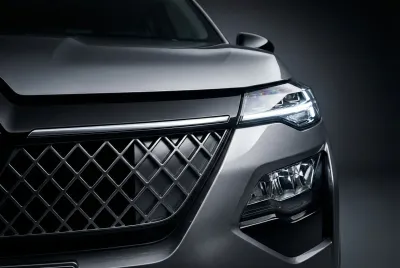 Gros plan emblématique de la calandre et du phare LED du Renault Kardian, mettant en valeur son design moderne et son contraste fort.