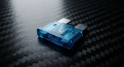 Gros plan d'un fusible automobile bleu sur une surface sombre